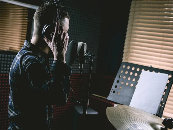 The young guy singing in recording studio