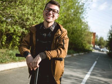 Kickscooter 'daki genç adam akıllı telefonlu.