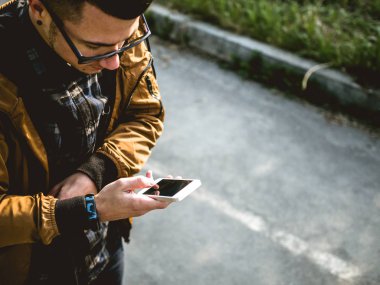 Kickscooter 'daki genç adam akıllı telefonlu.