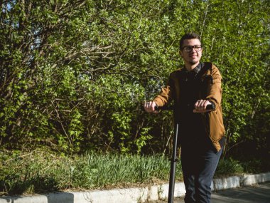 Kickscooter 'daki genç adam akıllı telefonlu.