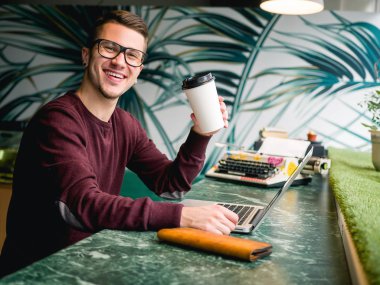 kafede dizüstü bilgisayar ve kahve kağıdı fincan ile öğrenci