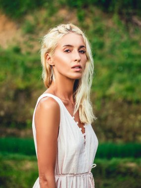 Pirinç tarlalarında hasır şapkalı sarışın kız ve beyaz elbise