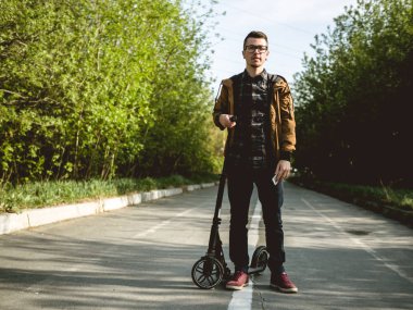 Smartphone ile kickscooter üzerinde Yong adam