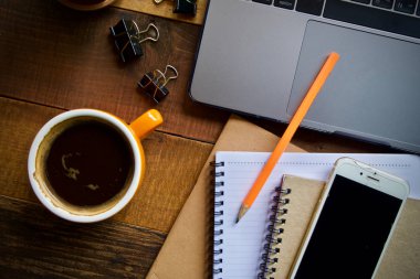 Kahve fincanı sıcak ve dizüstü defter kalem ahşap masa masa üzerinde