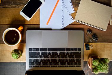 Kahve fincanı sıcak ve dizüstü defter kalem ahşap masa masa üzerinde