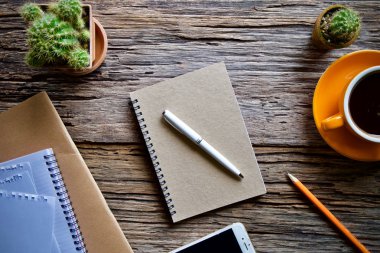 Kahve fincanı sıcak ve dizüstü defter kalem ahşap masa masa üzerinde