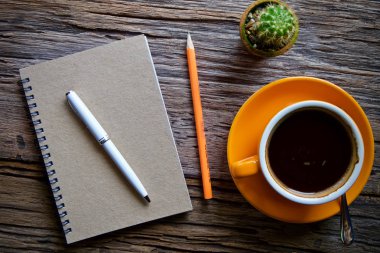 Kahve fincanı sıcak ve dizüstü defter kalem ahşap masa masa üzerinde