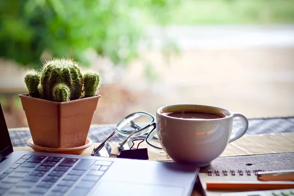 Coffee cup hot and laptop notebook on wooden table desk