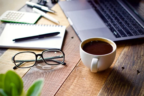 Coffee cup hot and laptop notebook on wooden table desk