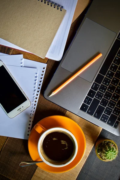 Coffee cup hot and laptop notebook pen on wooden table desk