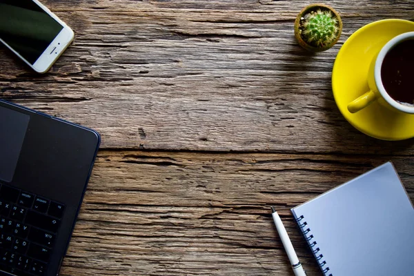 Coffee cup hot and laptop notebook pen on wooden table