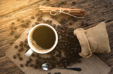 Kahve çekirdekleri kupa ahşap masa üzerinde sıcak