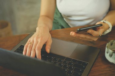 Dizüstü bilgisayar kullanan ve kahve fincanı içen kadınlar