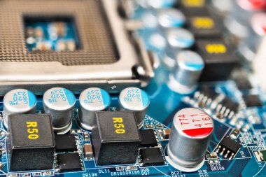 Bilgisayar anakart ayrıntı. Nabız kaynağı devreleri. Donanım Elektronik komponentleri yakın çekim. CPU soket, endüktörler, kapasitörler. Yüzey montaj teknolojisi ve elektronik sanayi geliştirme fikri.