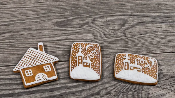 传统华丽的圣诞姜饼在木制背景 装饰姜饼糕点在房子形状 并在雪中手绘教堂 美丽的芳香烘焙糖果与糖衣 — 图库照片
