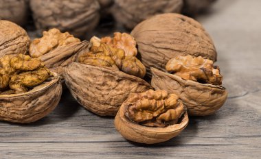 Yarım ile kısmen soyulmuş fındık grup portre kabuklar. Ceviz çatlama. Ahşap arka plan üzerinde fındık etli kırık nutshells yarısı. Lezzetli ceviz badem. Sağlıklı vejetaryen organik gıda.