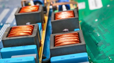 Bakır Bobinler ve devre kartlarına dizüstü anakartlar için yakın çekim. Renkli arka plandan elektronik ve bilgisayar parçaları. Endüktörler sökülüp floresan lamba başlayanlar içinde. Sanayi, eco, e-atık.