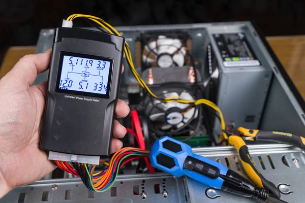 Testador de mão da unidade de fonte de alimentação. Caixa de computador aberta — Fotografia de Stock