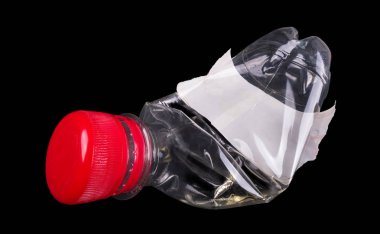 Kullanılmış plastik şişe. Kırmızı kap ve beyaz etiket. Siyah arka planda yalıtılmış