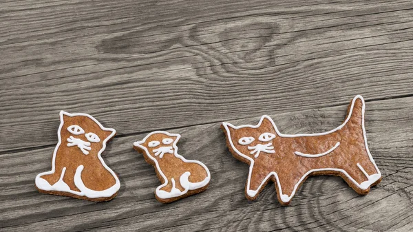 Cute baked gingerbread sweets. Cat shapes on wood background — Stock Photo, Image