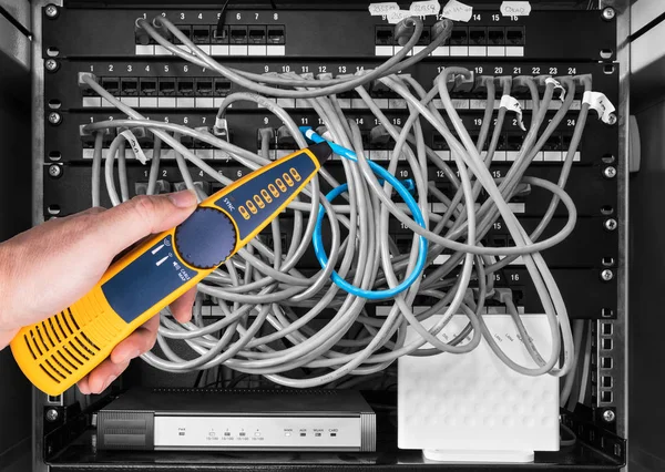 Network cable tester detail. Measuring probe in hand of expert on black and white background