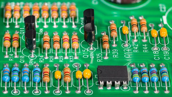 Kolorowe komponenty elektroniczne. Rezystory, tranzystory, kondensatory i układ scalony na płytce PCB — Zdjęcie stockowe