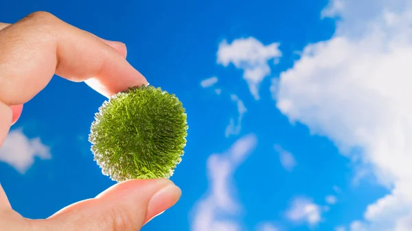 Moldavite. Rare green meteoric gem in hand of collector. Blue sky — Stock Photo, Image