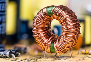 Basılı devre kartına lehimlenmiş bakır telli indüksiyon bobini. Manyetik ferit çekirdekli toroidal indüktör. Elektronik bileşenler elektrik dağıtım modu ünitesinde. Seçici odak.