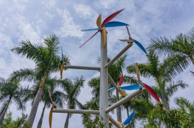 Palmiye ağacı mavi gökyüzü arka plan ile çevrili yel değirmeni