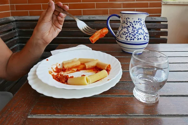 Hand Met Een Vork Van Macaroni Met Tomatensaus — Stockfoto