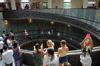 VATICAN, VATICAN CITY - 14 JULY 2018: People descending the modern 'Bramante' spiral stairs of the Vatican Museums, designed by Giuseppe Momo in 1932 clipart