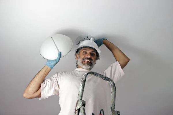 Man Die Een Lamp Aan Het Plafond Installeert — Stockfoto