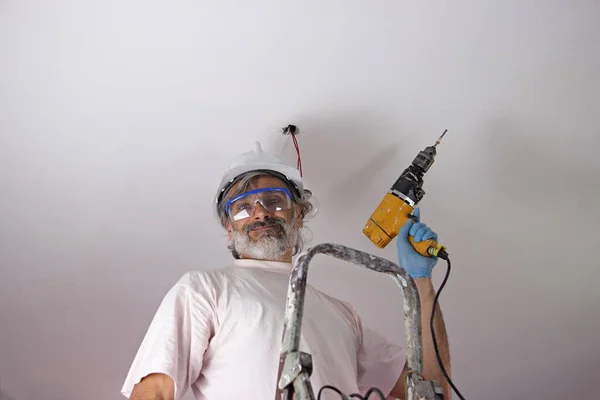Man Med Elektrisk Borr Montera Lampa Taket — Stockfoto