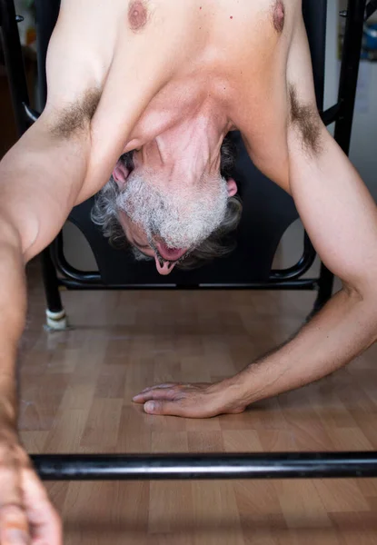 Mature Man Using Inversion Table Gym Stock Image