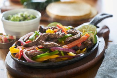 buharlı sıcak Meksika sığır fajitas biber ve guacamole yan demir tavada