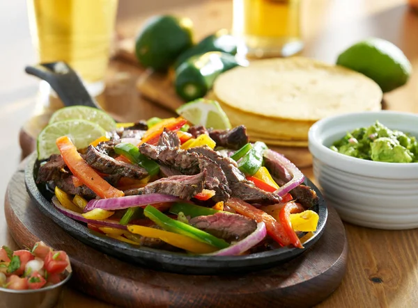 Meksika sığır eti fajitas guacamole ve bira ile demir tavada