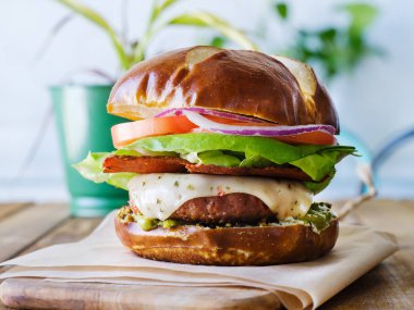 Vegan peynirli burger pretzal bun ve etsiz domuz pastırması