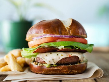 Vegan peynirli burger pretzal bun ve etsiz domuz pastırması