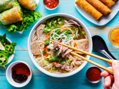 eating colorful vietnamese pho bo with chopsticks from top down view clipart