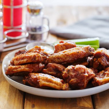 ahşap masaya tabak Barbekü tavuk kanadı çiftlik sosu ve kereviz ile sopa