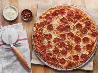 ahşap masa üstte büyük pepperoni pizza görünümü