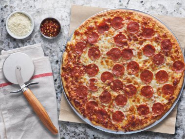 Tepegöz içinde mermer sayaç üzerinde büyük pepperoni pizza kompozisyon yatıyordu