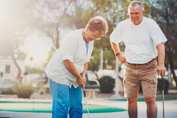 高级夫妇打迷你高尔夫享受退休的生活方式 — 图库照片