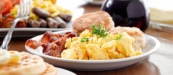 Huge breakfast plate with scrambled eggs, bacon and biscuits — Stock Photo, Image