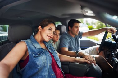 Anne, baba ve oğullu İspanyol bir aile kamyonda oturmuş dışarıya bakıyor.