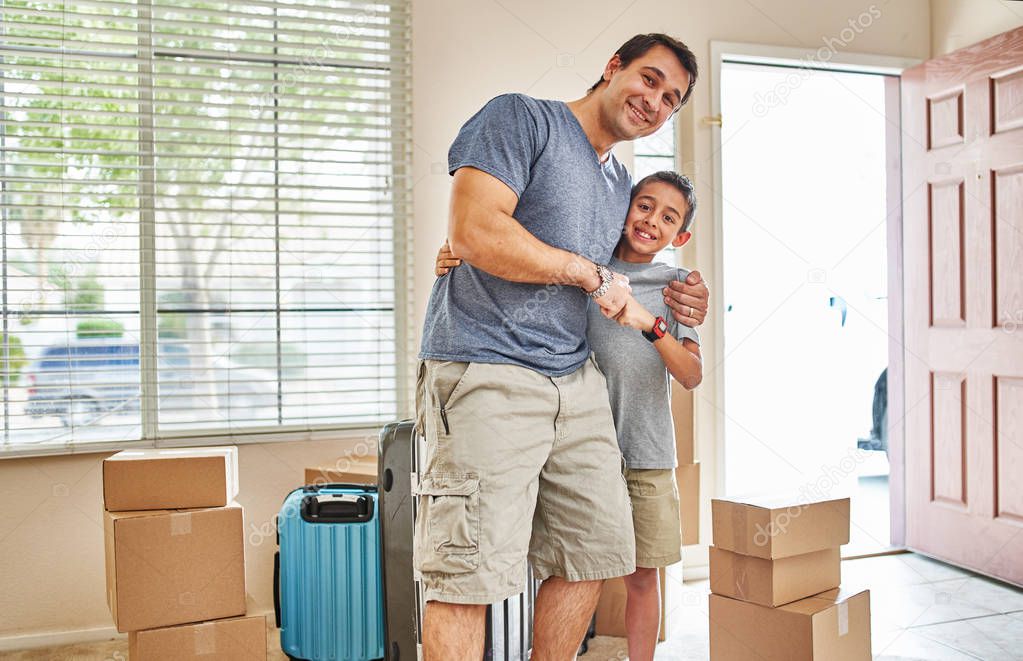 happy father and son moving into new house portrait