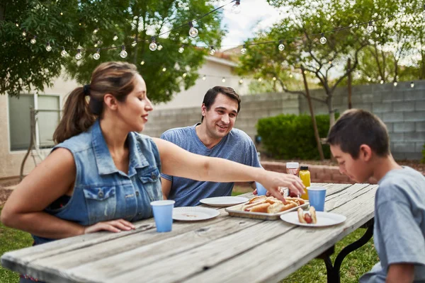 Happy Hispanic Family Eating Grilled Hot Dogs Picnic Table Backyard — Stock Photo, Image