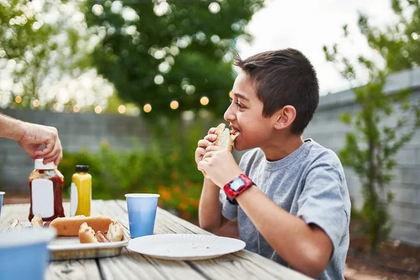 Kleine Latino Jongen Eten Hotdog Bij Familie Bbq Buiten Tuin — Stockfoto
