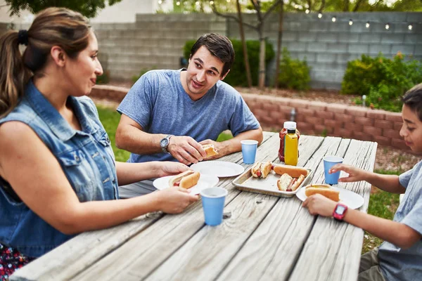 Happy Hispanic Family Eating Grilled Hot Dogs Picnic Table Backyard — Stock Photo, Image