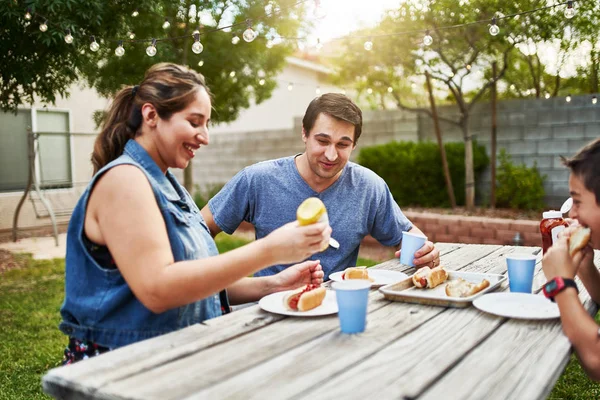 Happy Hispanic Family Eating Grilled Hot Dogs Picnic Table Backyard — Stock Photo, Image